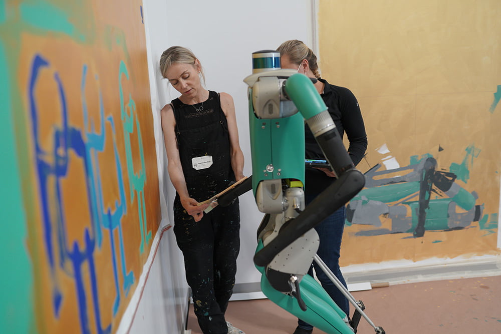 Agnieszka Pilat helping Digit paint during her residency at Agility Robotics.